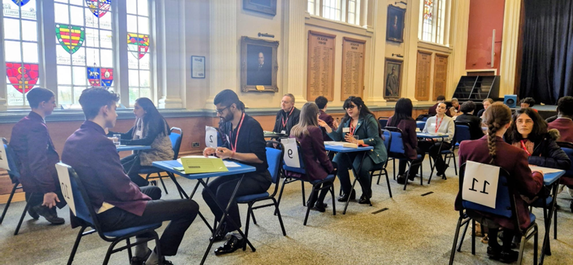 A school hall set up with individuals having mock interviews